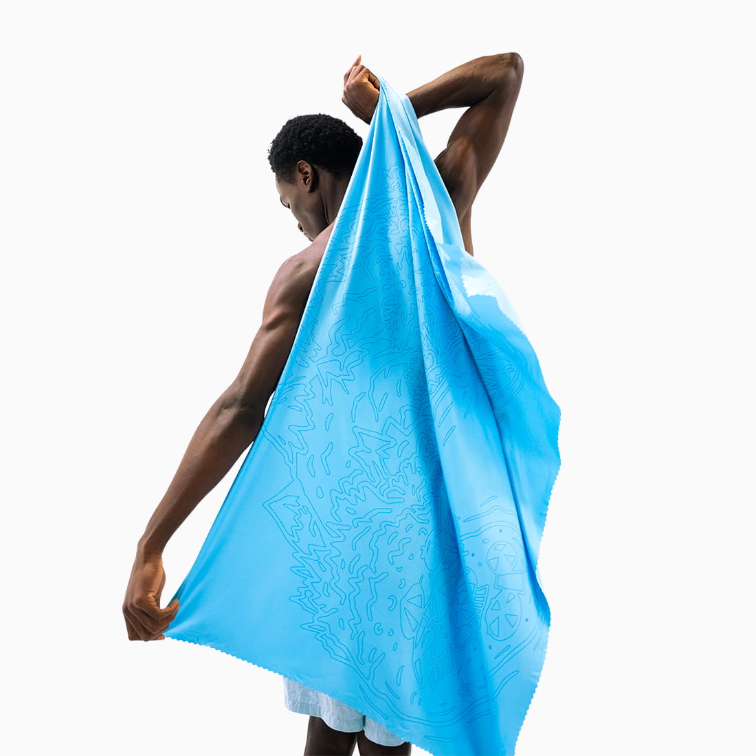 Air Towel™ Coziya® bleue utilisée homme - 120x80cm déployée plage bain